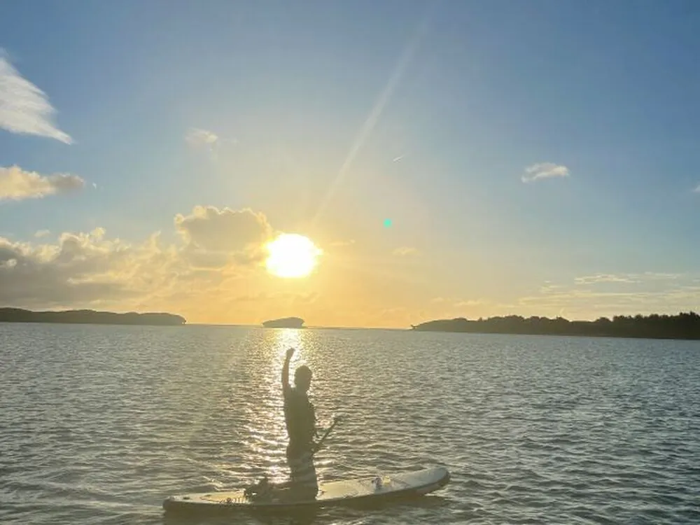 久米島の夕陽の海でSUPを楽しむ様子